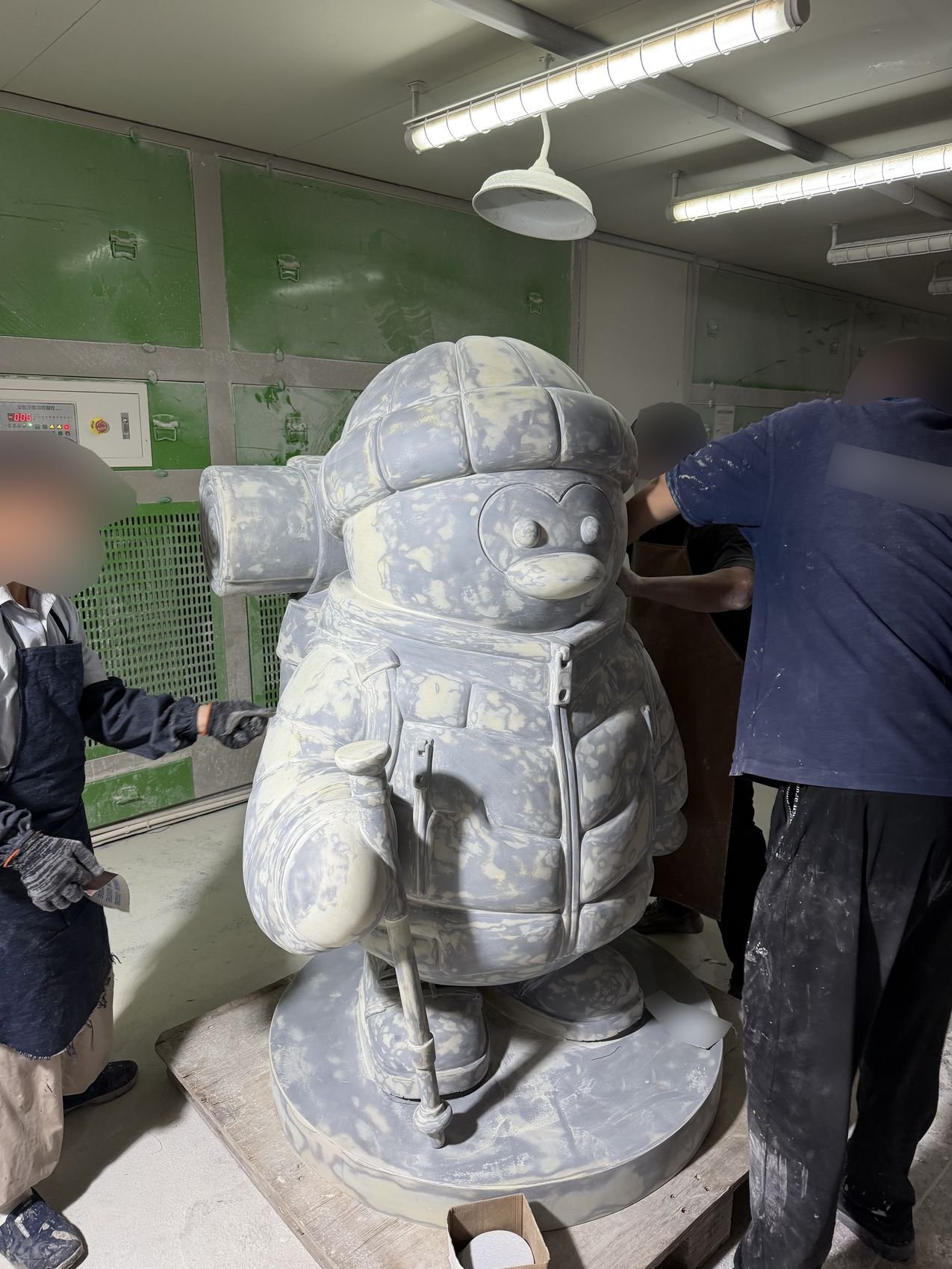 Workshop sanding and surface preparation on a custom mascot sculpture