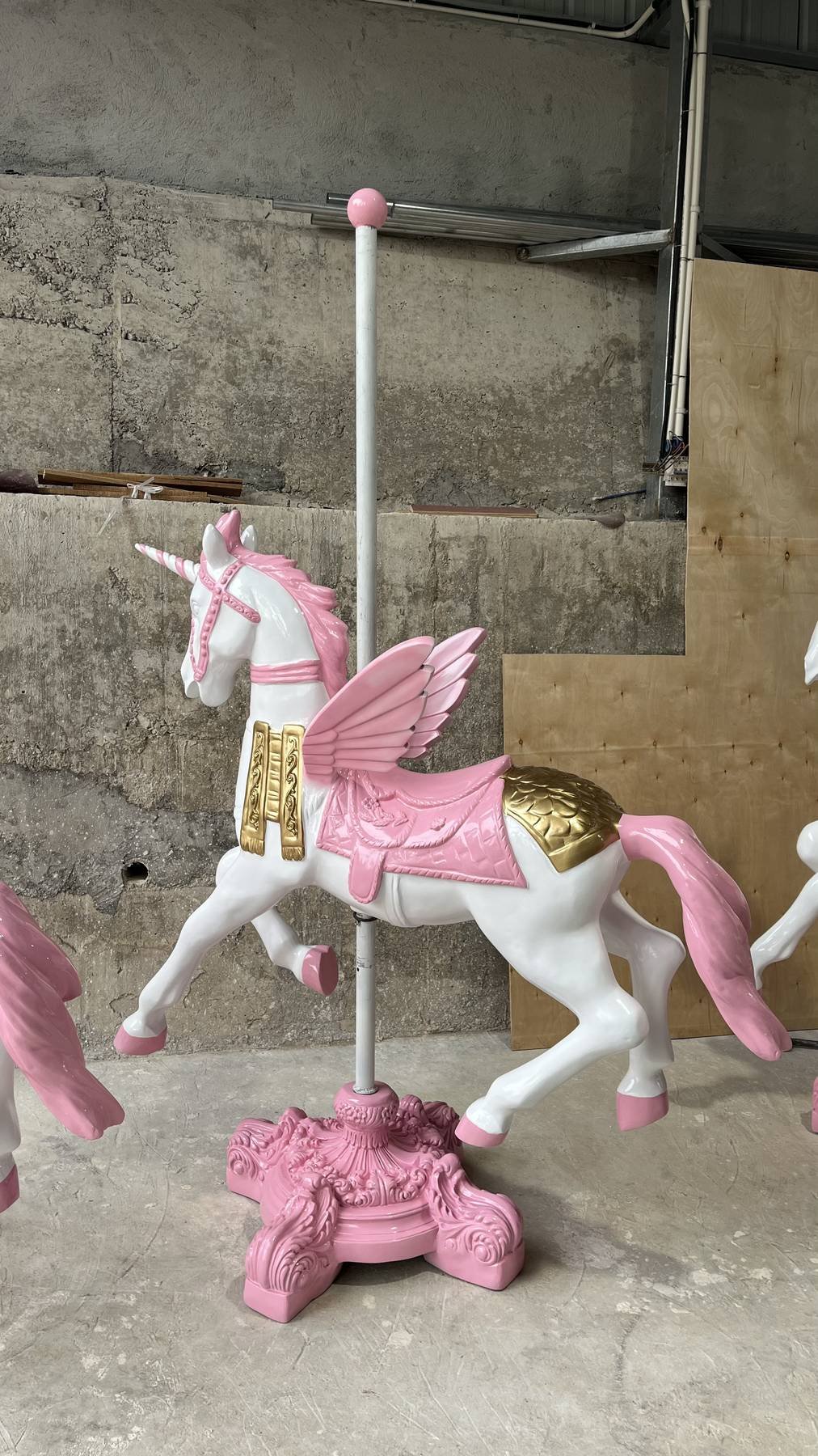 White Pegasus prop with pink wings and a decorative base