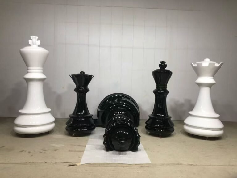 Giant black and white chess pieces arranged in a workshop