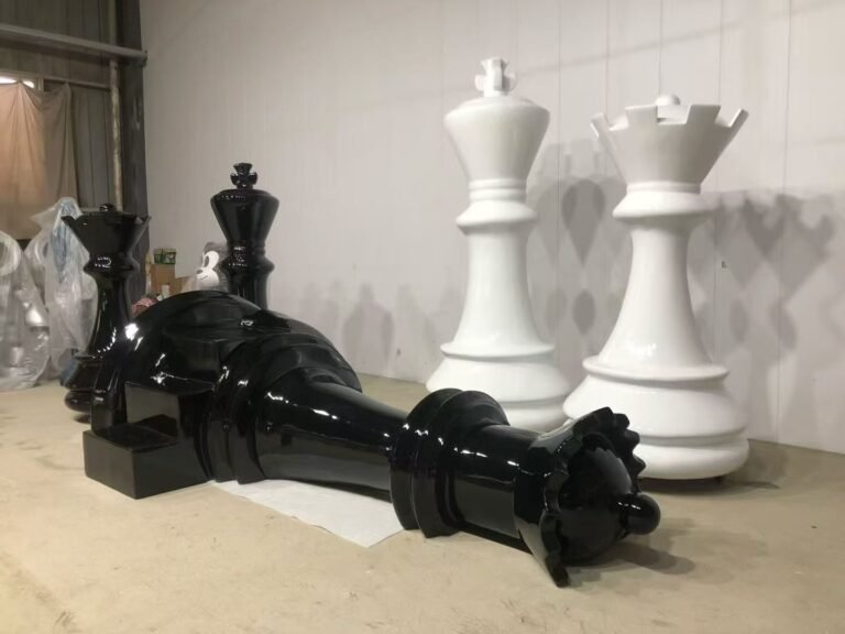 Gloss black chess piece resting in front of white chess props