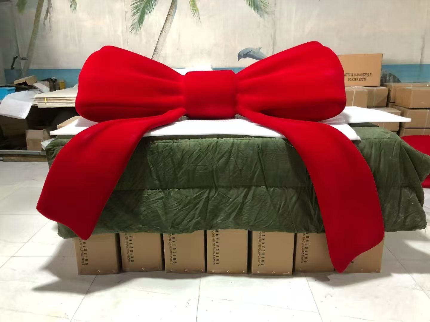 Giant red bow displayed upright on a workshop table