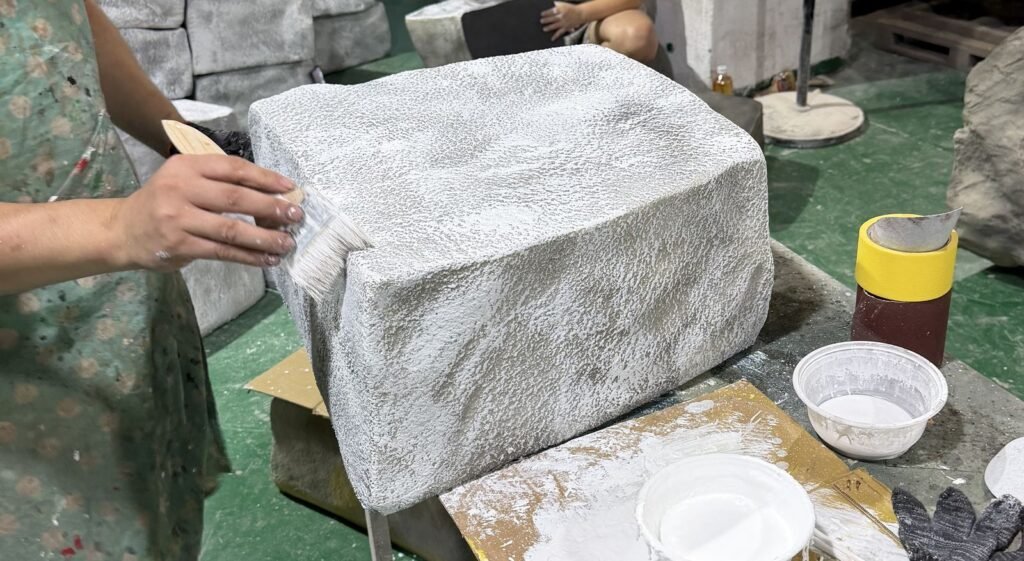 Hand-finishing the surface of a faux stone block