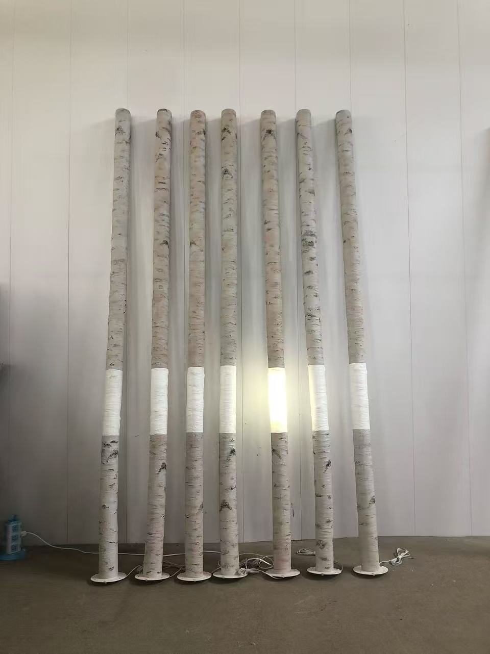 Illuminated birch-style display trunks on circular bases