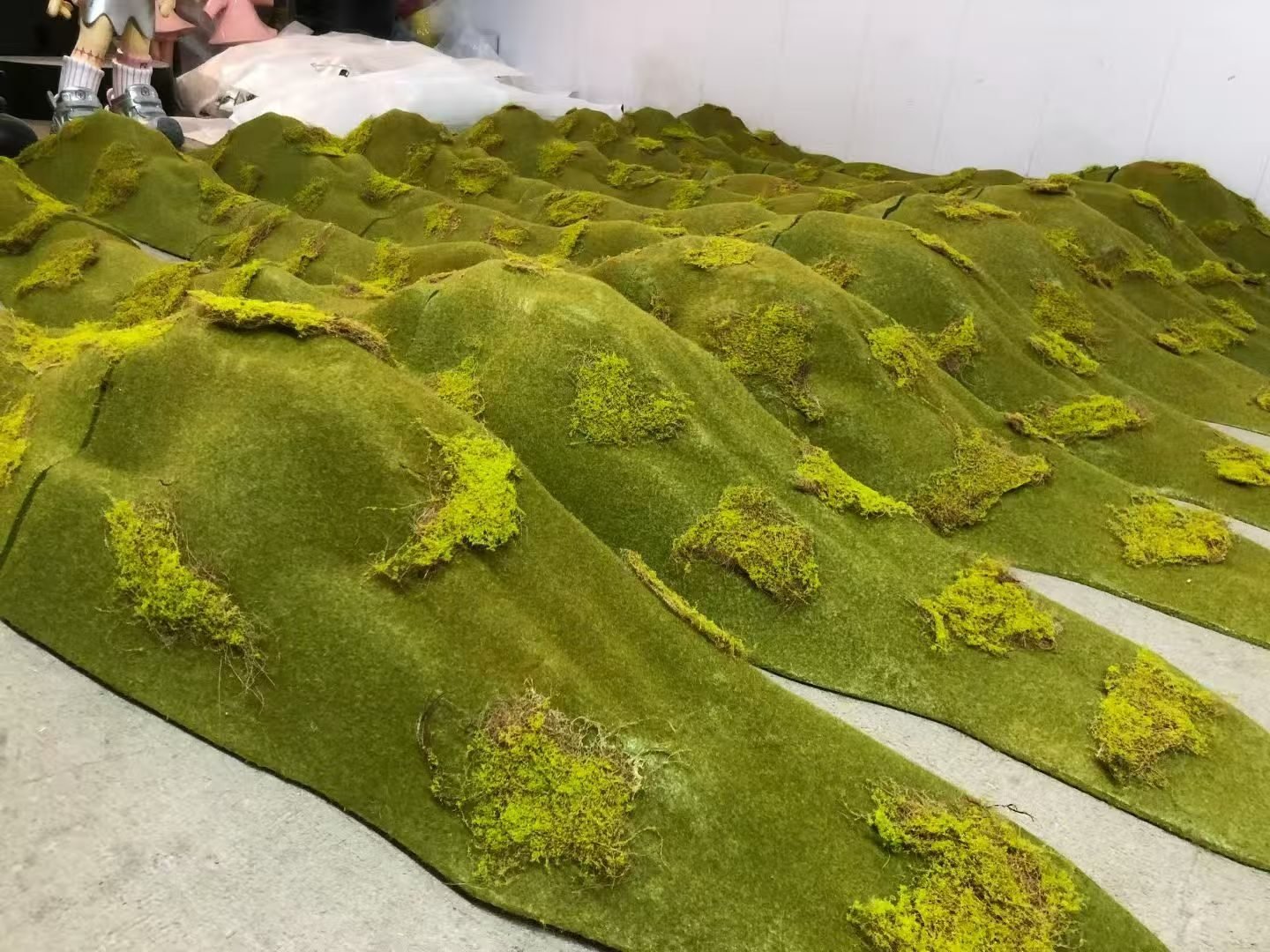 Green moss-covered terrain display modules arranged in rows