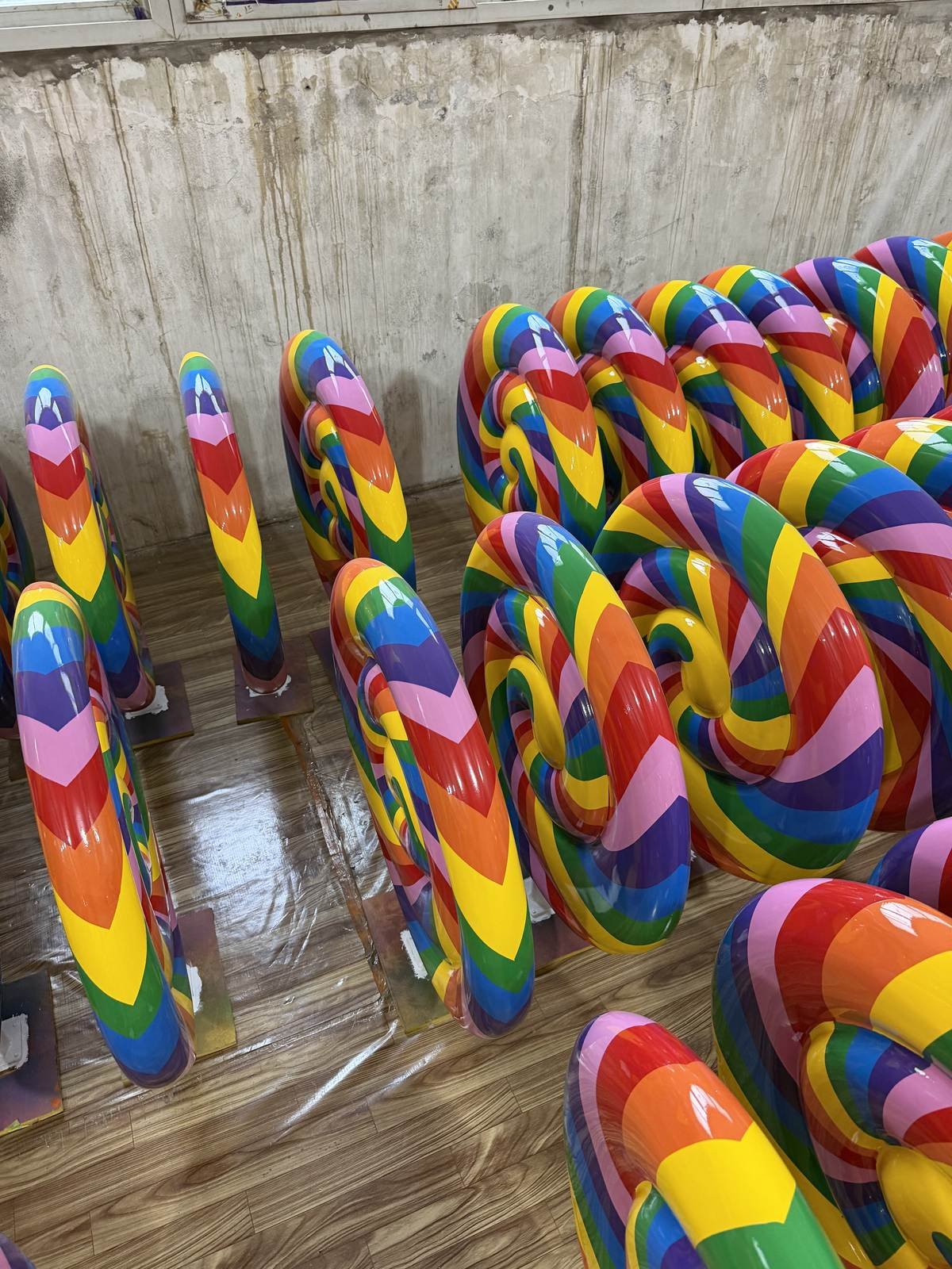 Rows of finished rainbow spiral lollipop display props viewed at an angle.