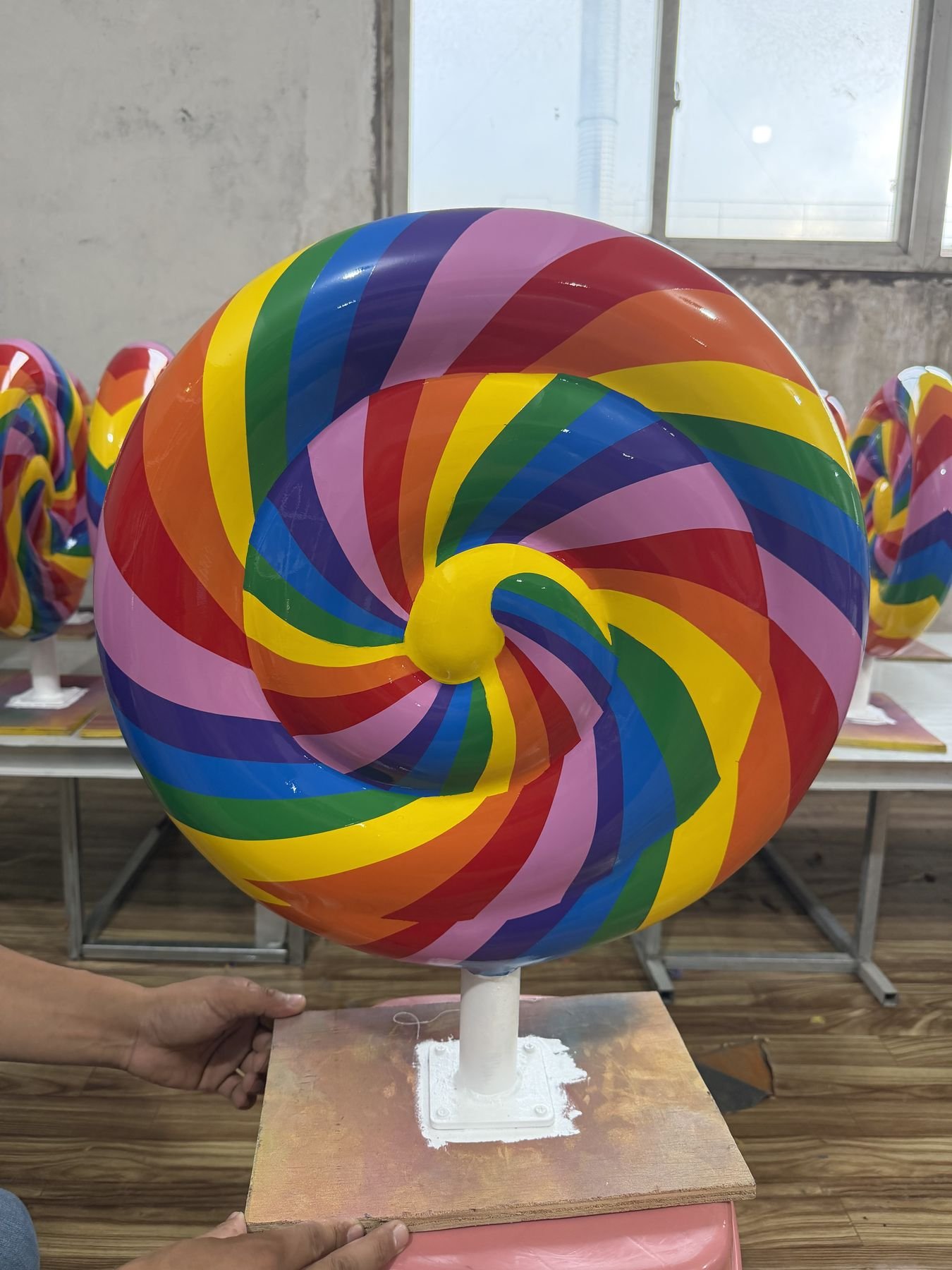 Finished rainbow spiral lollipop display prop with matching pieces in the workshop.