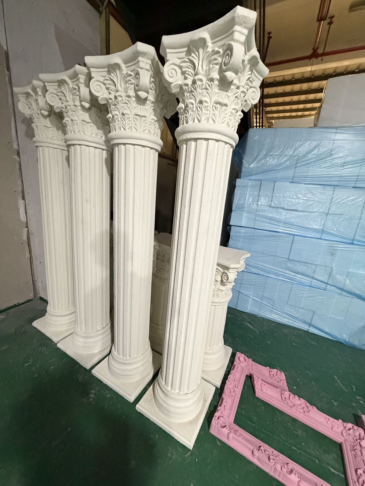 White Roman column display props with fluted shafts and ornate capitals