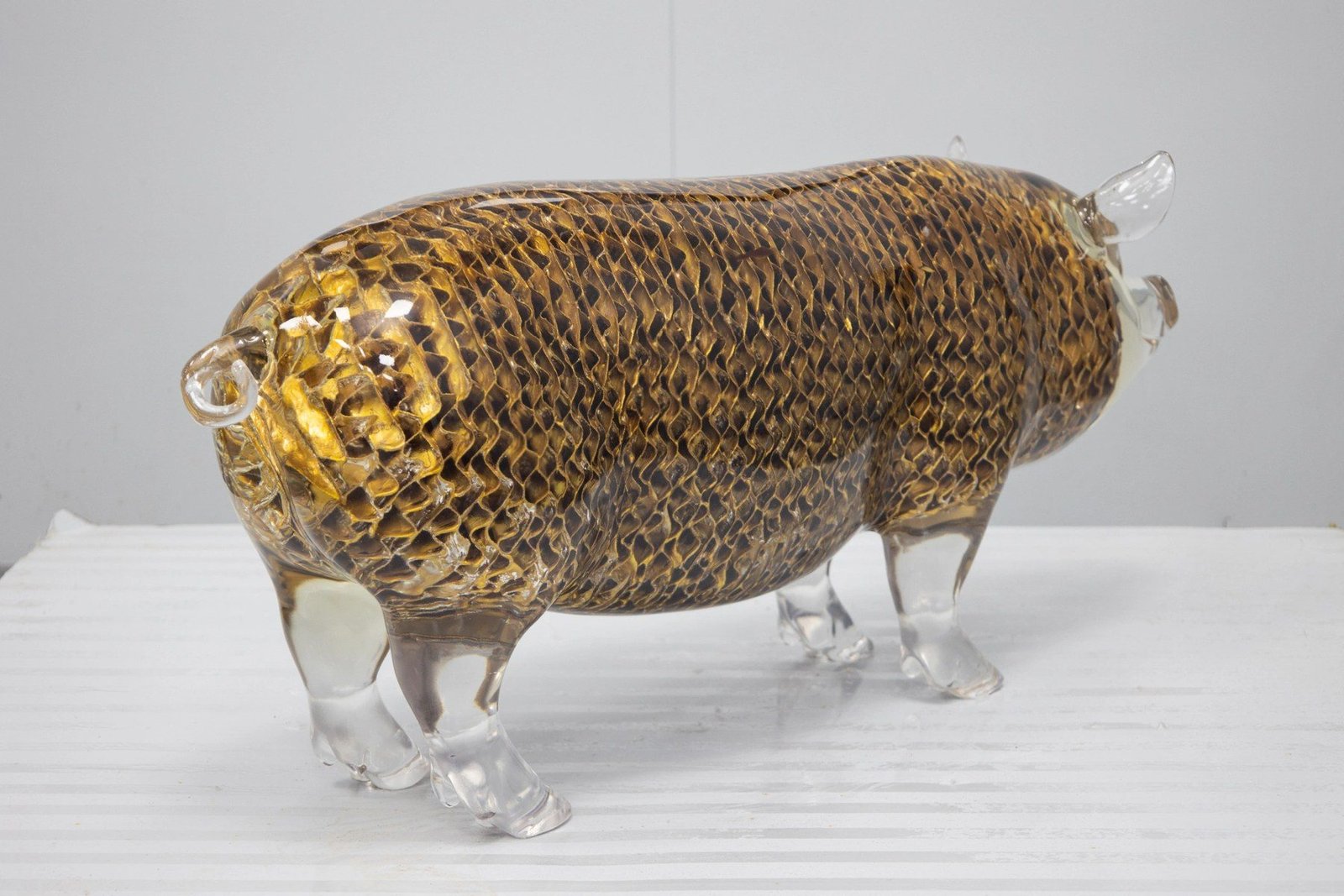 Three-quarter view of the transparent pig display sculpture