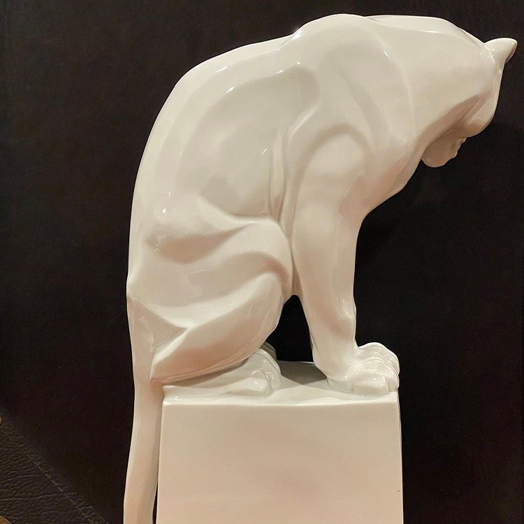 White panther sculpture with a curved tail and square base
